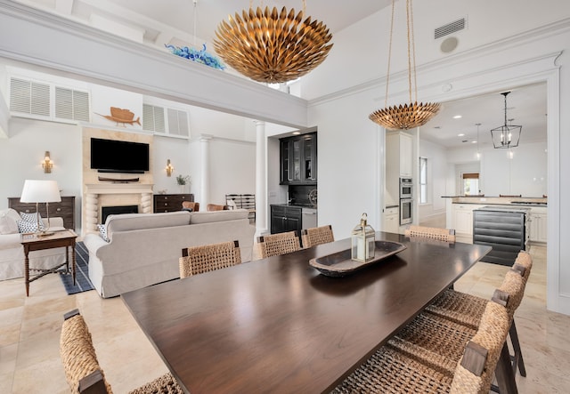 tiled dining space with a high ceiling and ornate columns