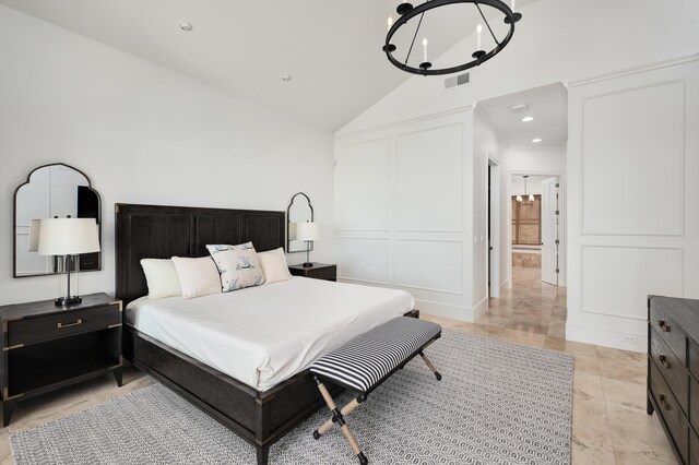 tiled bedroom featuring an inviting chandelier and lofted ceiling