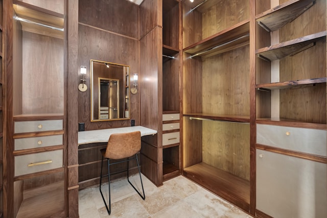 spacious closet with built in desk and tile floors