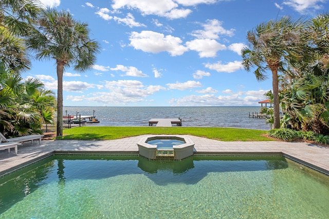 view of swimming pool with an in ground hot tub and a water view