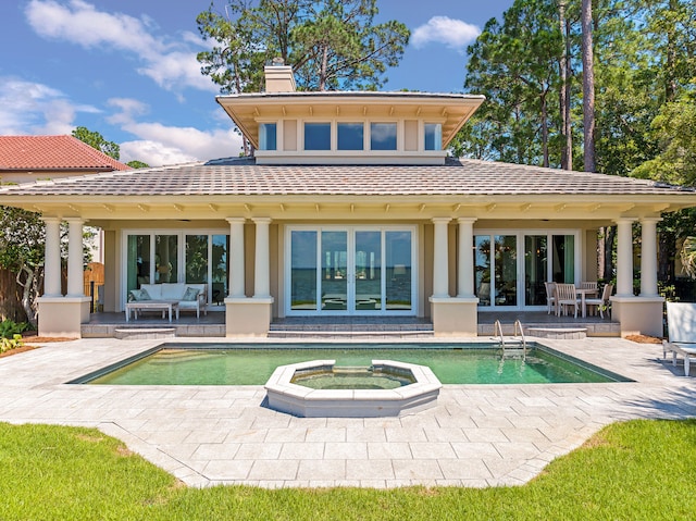 back of house featuring a pool with hot tub, an outdoor hangout area, and a patio