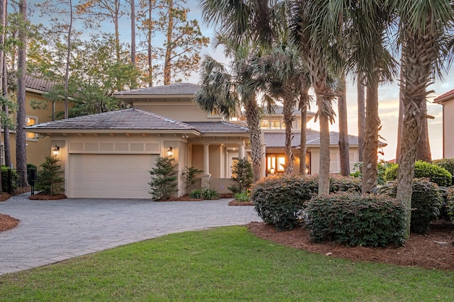 view of front of home featuring a garage and a lawn