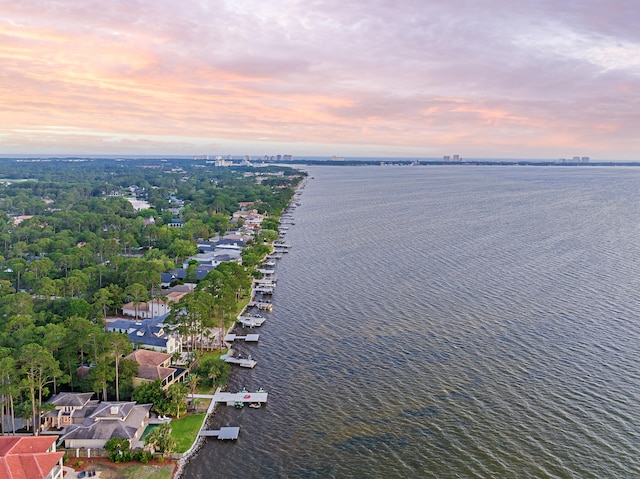 aerial view at dusk featuring a water view