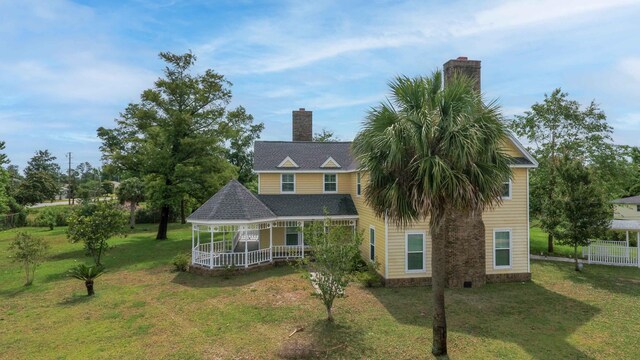 back of property featuring a lawn