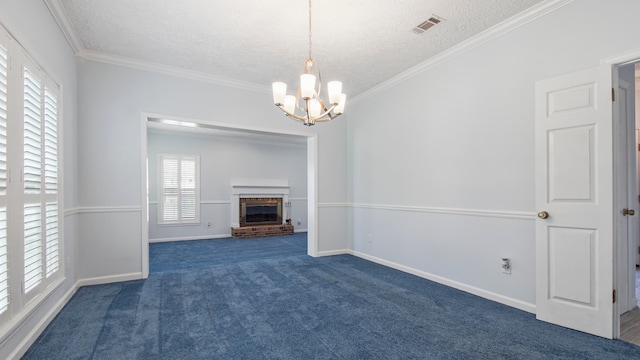 unfurnished living room with a textured ceiling, a fireplace, ornamental molding, a chandelier, and dark carpet