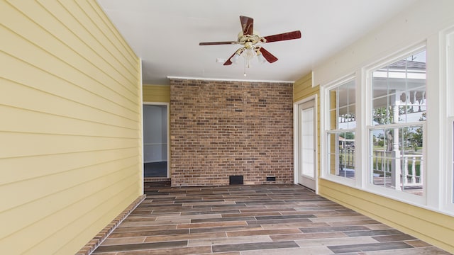 unfurnished sunroom with a healthy amount of sunlight and ceiling fan