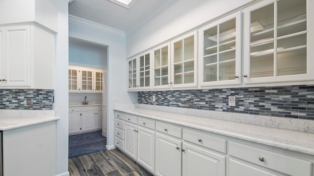 kitchen featuring sink, dark hardwood / wood-style flooring, white cabinets, and backsplash