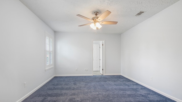 carpeted spare room with ceiling fan and a textured ceiling