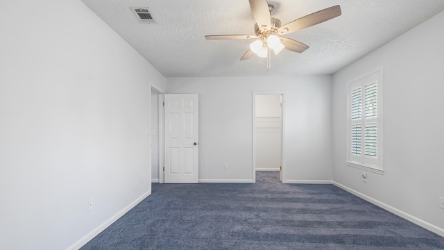 carpeted spare room featuring ceiling fan and a textured ceiling