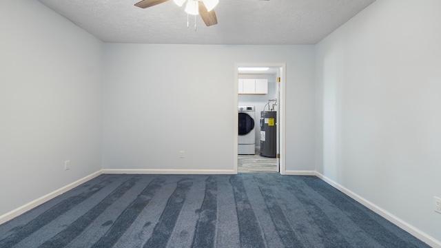 carpeted spare room featuring washer / dryer, a textured ceiling, ceiling fan, and water heater