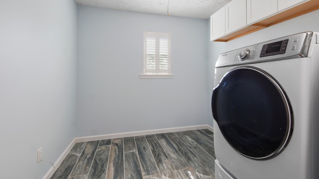 clothes washing area with dark hardwood / wood-style floors, washer / clothes dryer, and cabinets