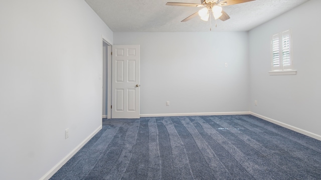 unfurnished room with a textured ceiling, dark colored carpet, and ceiling fan