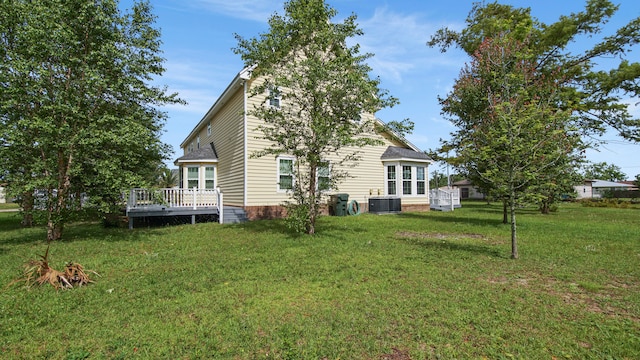 back of property featuring a wooden deck, a yard, and central air condition unit