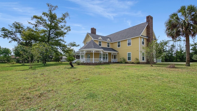 view of side of home with covered porch and a yard