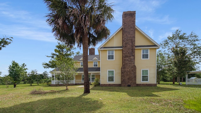 rear view of house featuring a lawn