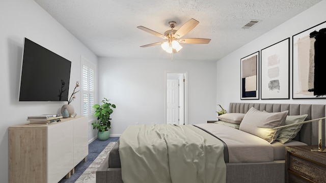 carpeted bedroom featuring ceiling fan and a textured ceiling