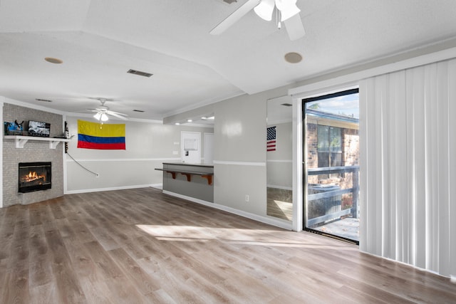 unfurnished living room featuring hardwood / wood-style flooring, a fireplace, and ceiling fan