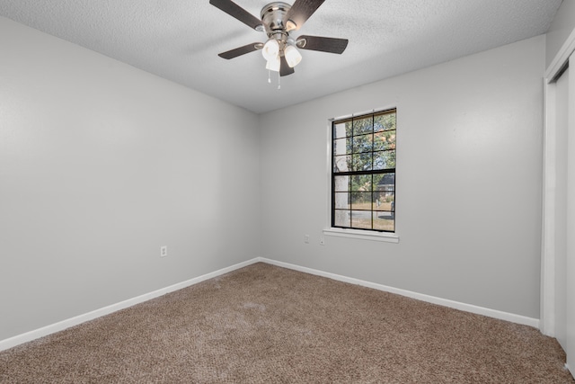 spare room with a textured ceiling, carpet, and ceiling fan