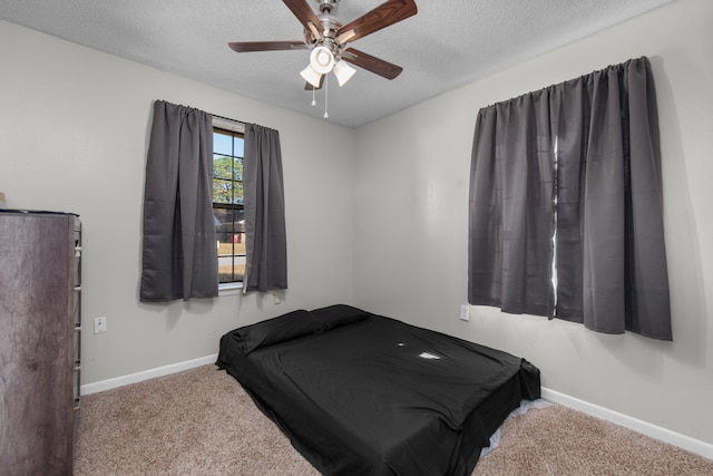 bedroom with carpet, ceiling fan, and a textured ceiling