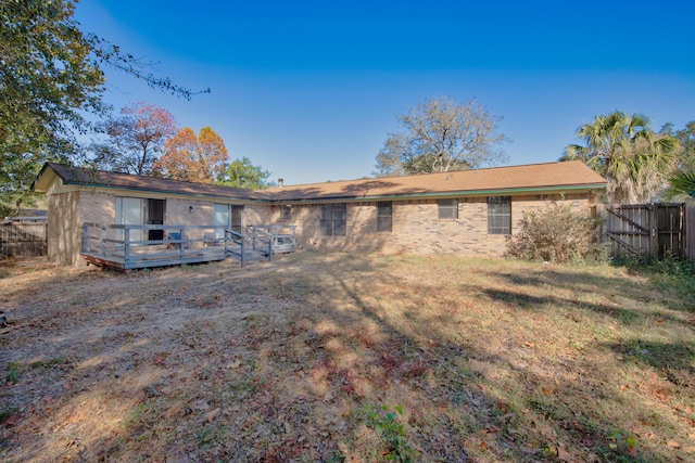 rear view of property featuring a wooden deck