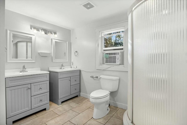 bathroom with tile patterned flooring, vanity, cooling unit, and toilet