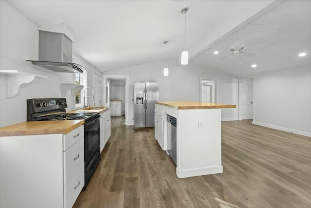 kitchen with white cabinets, wall chimney exhaust hood, butcher block counters, and appliances with stainless steel finishes