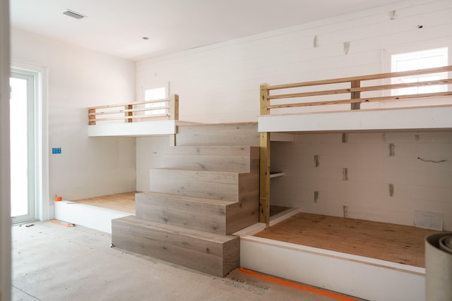 unfurnished bedroom with concrete floors and multiple windows