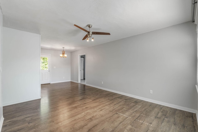 spare room featuring dark hardwood / wood-style flooring and ceiling fan with notable chandelier