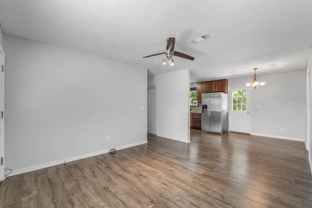 unfurnished living room featuring dark wood-type flooring and ceiling fan with notable chandelier