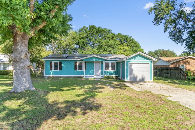 ranch-style house with a front yard, solar panels, and a garage