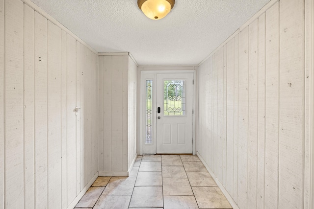 doorway featuring wood walls and light tile patterned floors