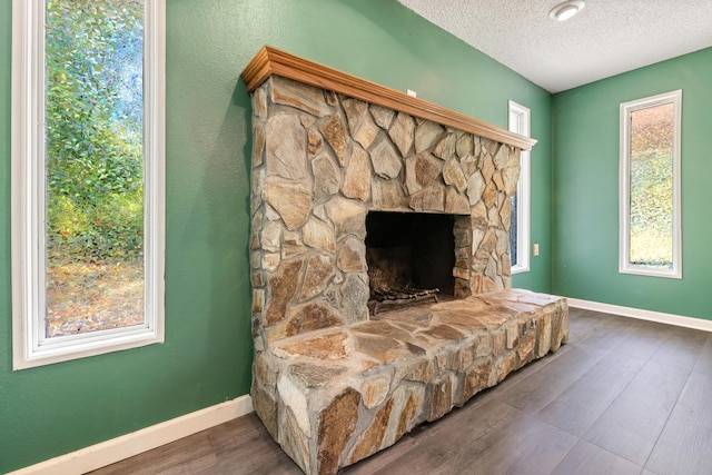 sitting room with a fireplace, a textured ceiling, and dark hardwood / wood-style floors