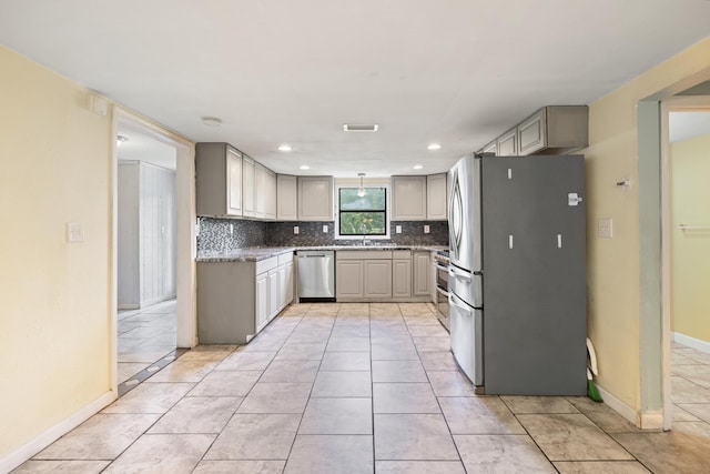 kitchen featuring gray cabinetry, sink, stainless steel appliances, tasteful backsplash, and light tile patterned floors