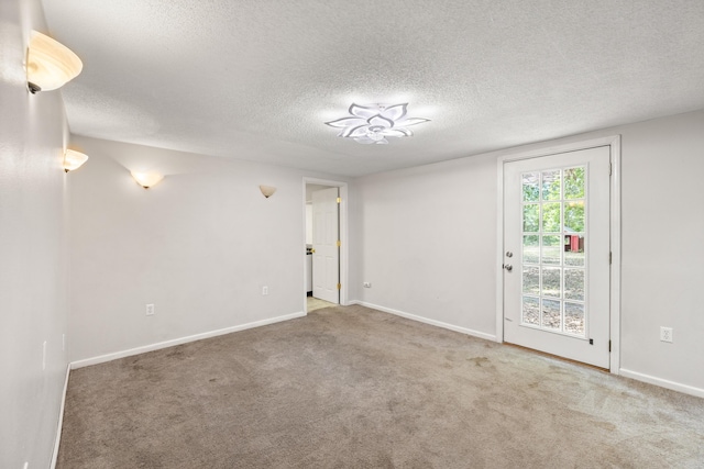 unfurnished room with carpet and a textured ceiling