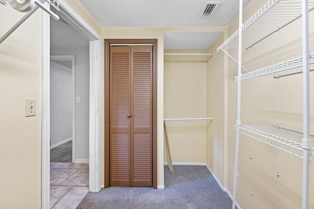 spacious closet featuring light colored carpet