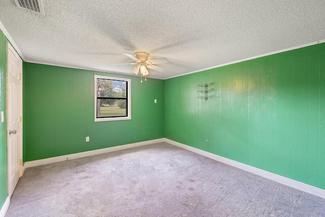 empty room with ceiling fan, crown molding, and carpet