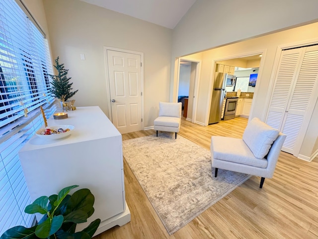 sitting room featuring lofted ceiling and light hardwood / wood-style flooring