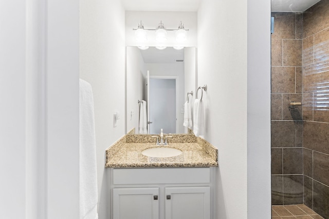 bathroom with tiled shower and oversized vanity