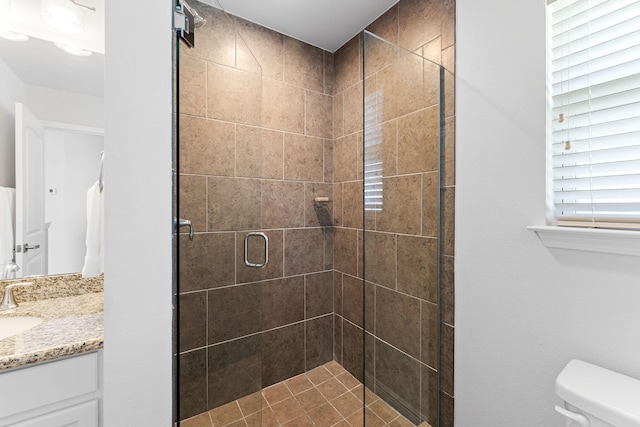 bathroom with a shower with door, vanity, and toilet