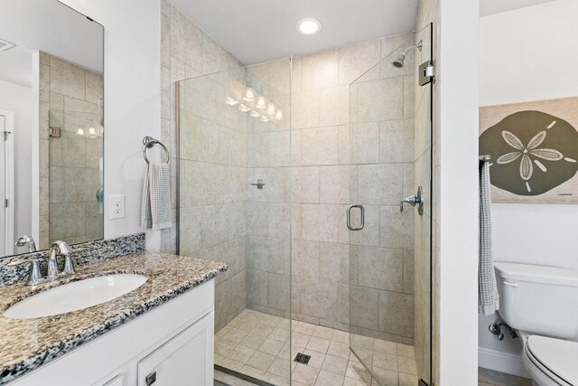 bathroom with an enclosed shower, oversized vanity, and toilet