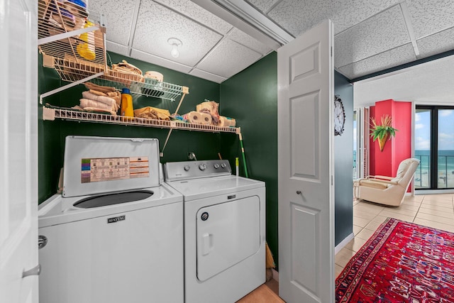 laundry area featuring washer and clothes dryer and light tile floors