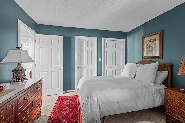 carpeted bedroom featuring a textured ceiling and a closet