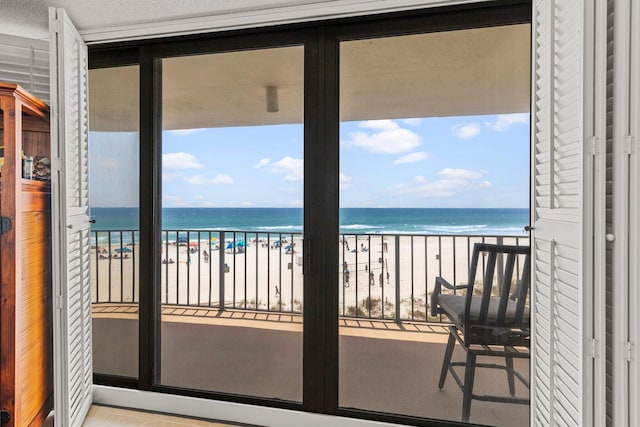 balcony featuring a beach view and a water view