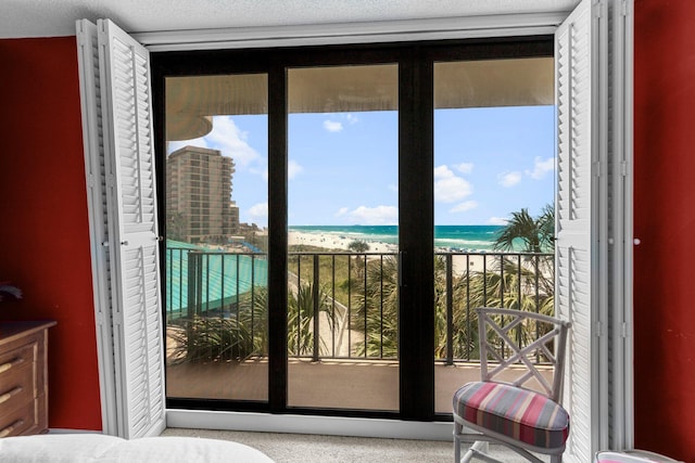 bedroom with a beach view, a textured ceiling, and a water view