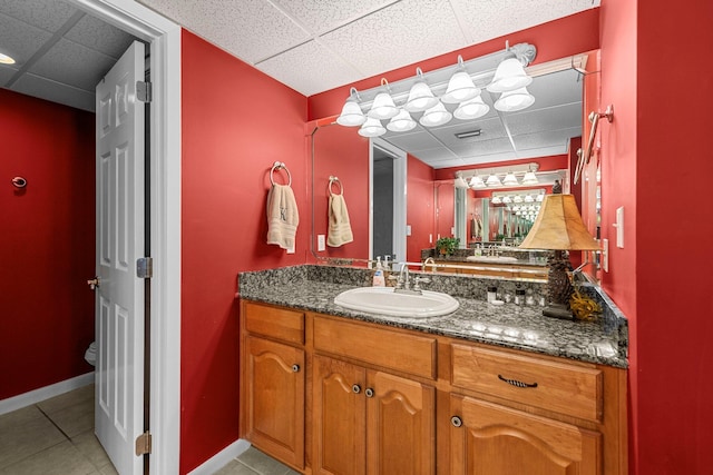 bathroom featuring tile flooring, large vanity, and a drop ceiling