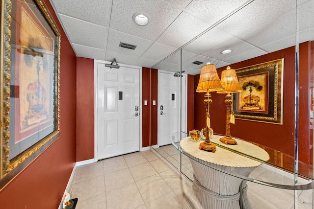 interior space featuring tile flooring and a paneled ceiling