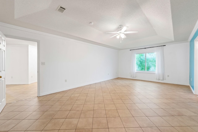 tiled empty room with a textured ceiling, ceiling fan, and a raised ceiling