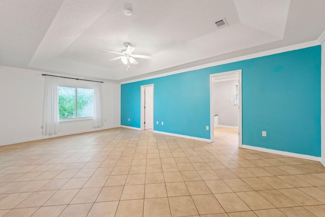 tiled empty room featuring crown molding, ceiling fan, and a raised ceiling