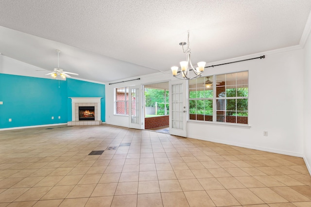 unfurnished living room with ornamental molding, lofted ceiling, ceiling fan with notable chandelier, a tiled fireplace, and light tile floors