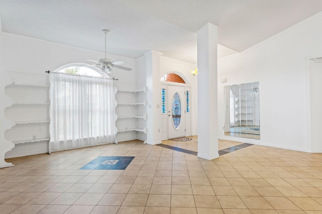 empty room with ornamental molding, ceiling fan, and light tile floors